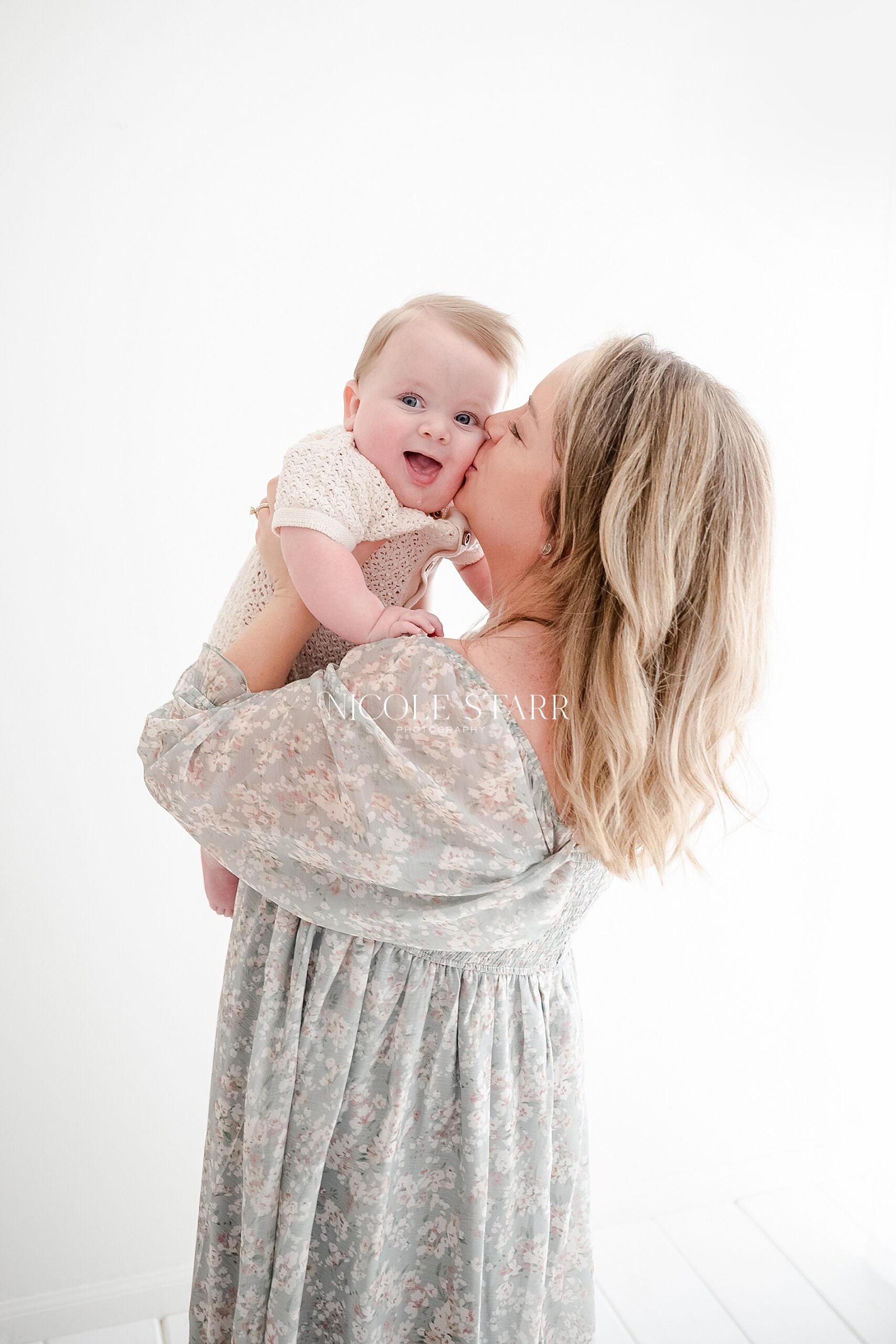 mom kisses baby's cheek