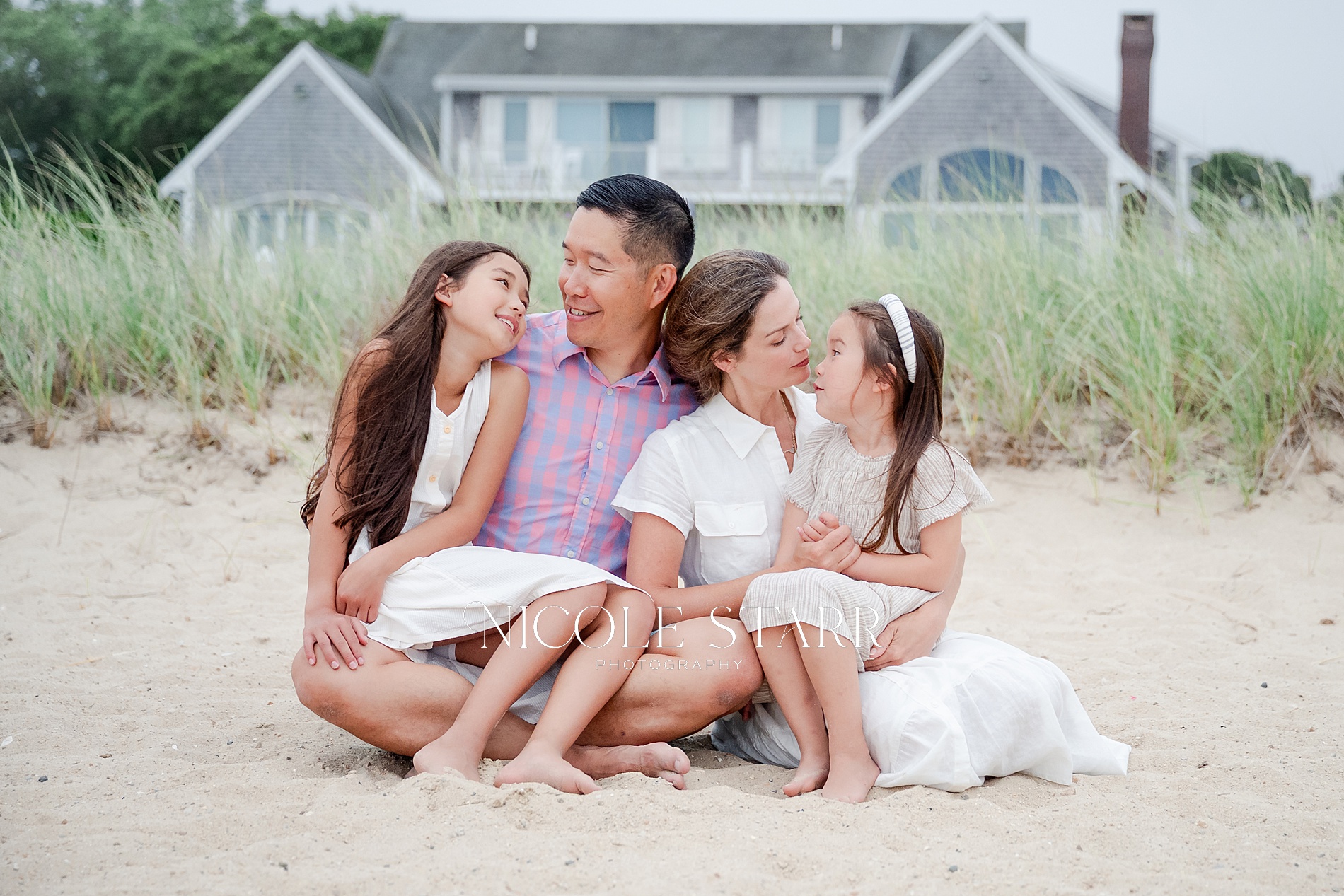 family of four sits together from Beach Family Portraits in Bourne, Cape Cod
