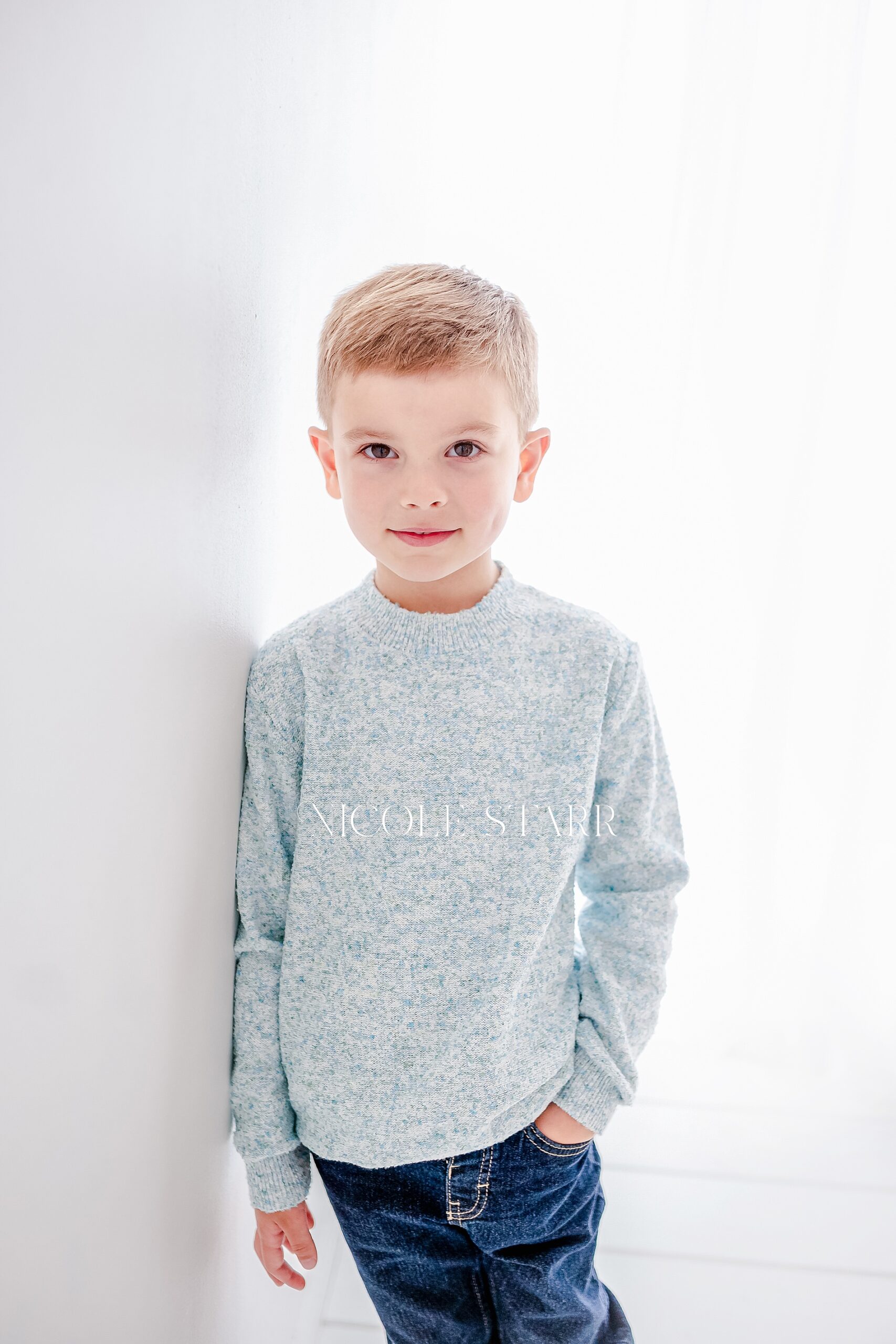 boy leans against wall in studio during Little Loves session
