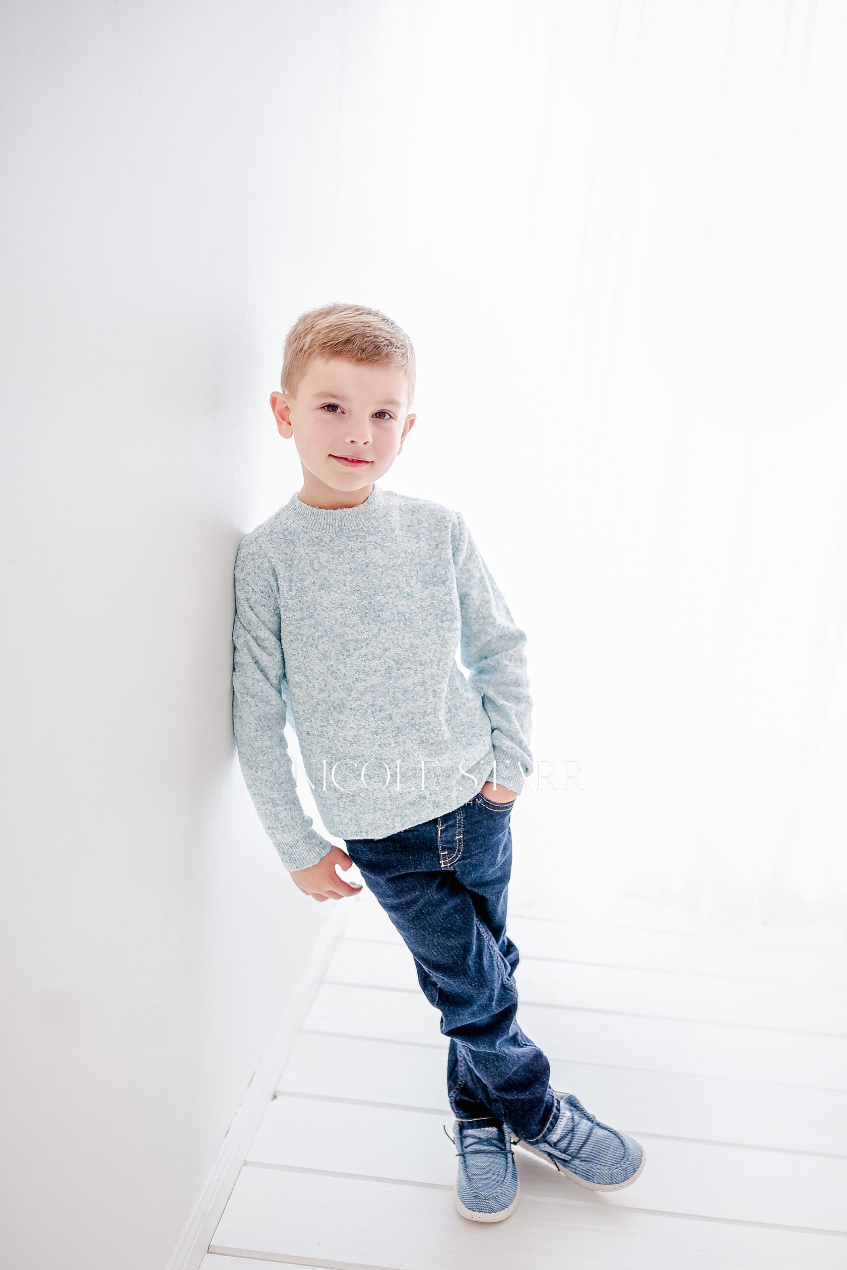 5 year old leans against wall during children's studio session