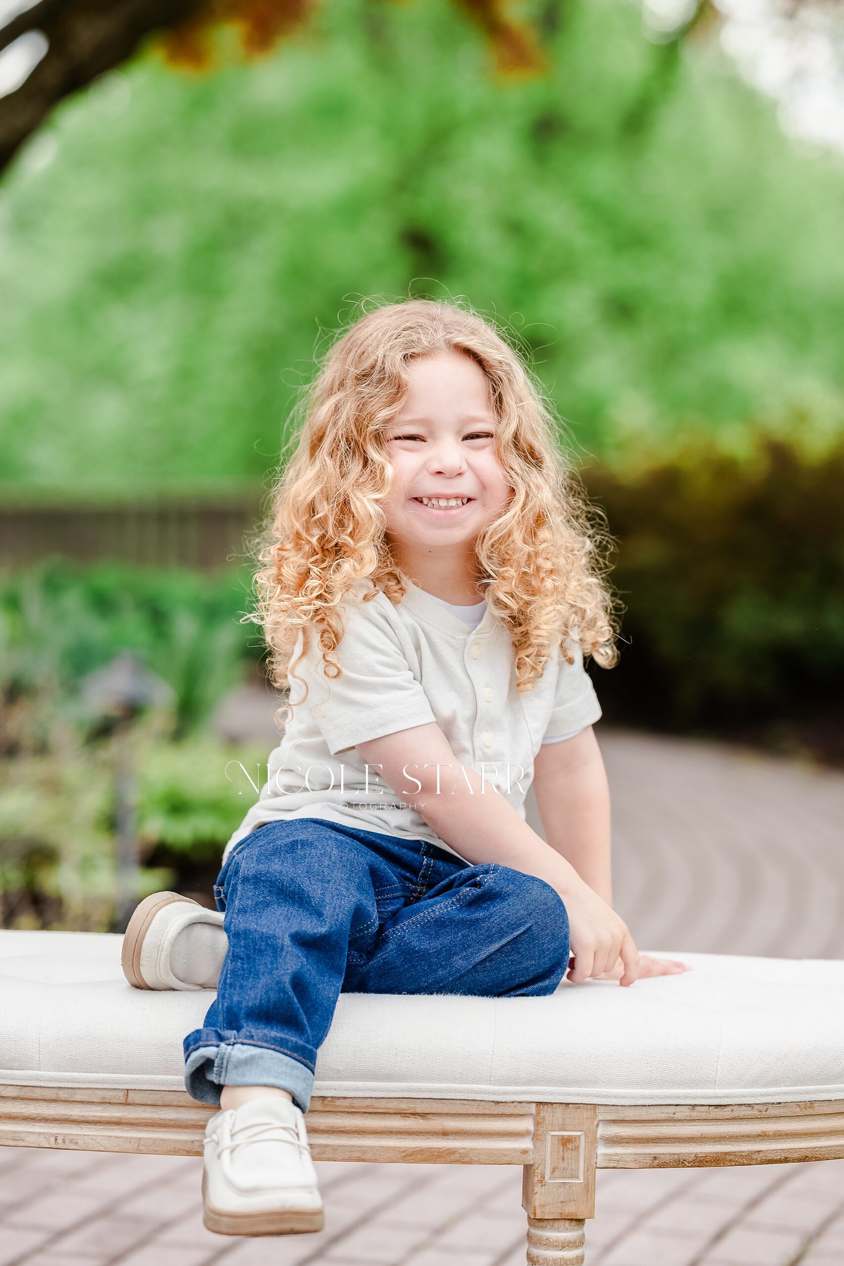 adorable little boy sits on bench for portraits