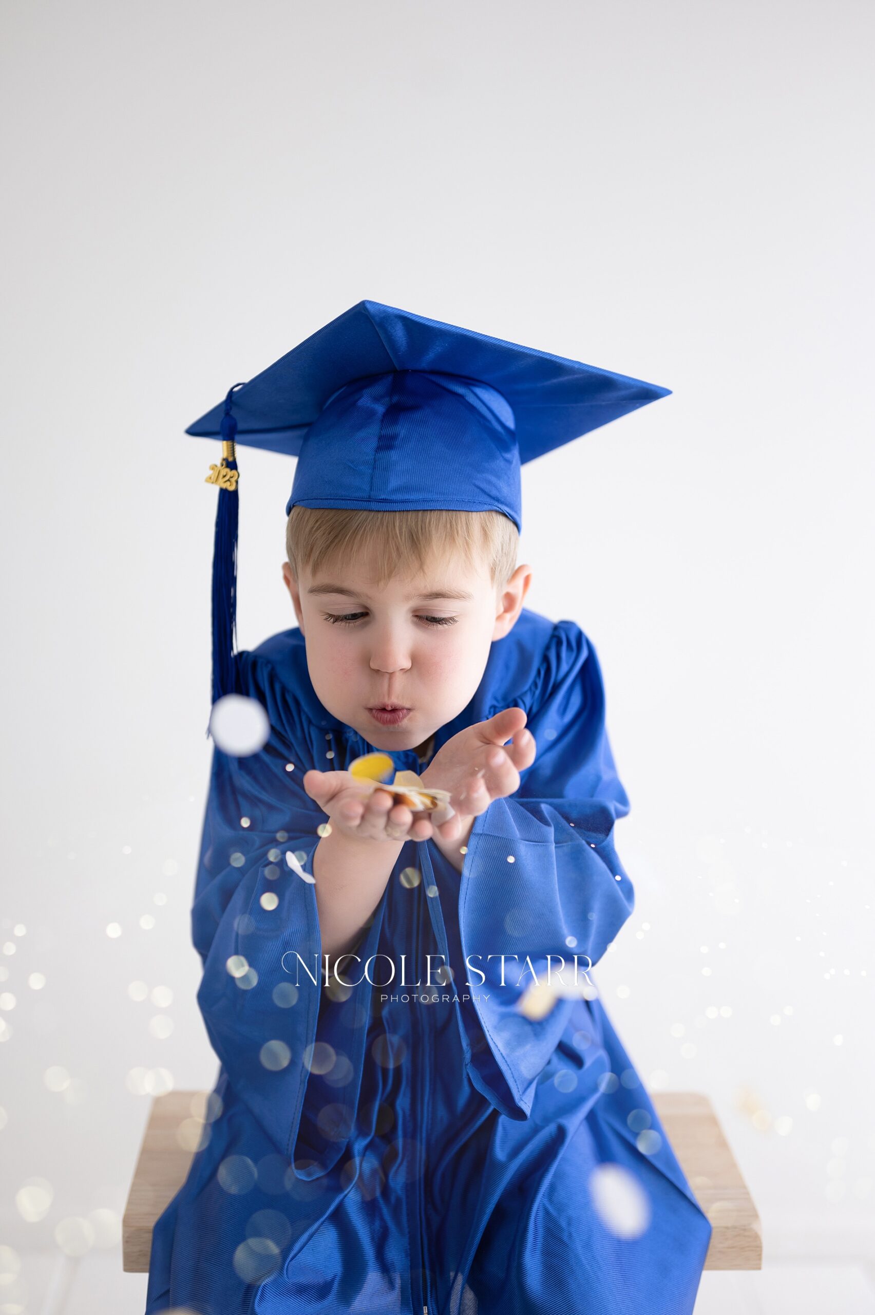 kindergartner blowing confetti during tiny graduate session