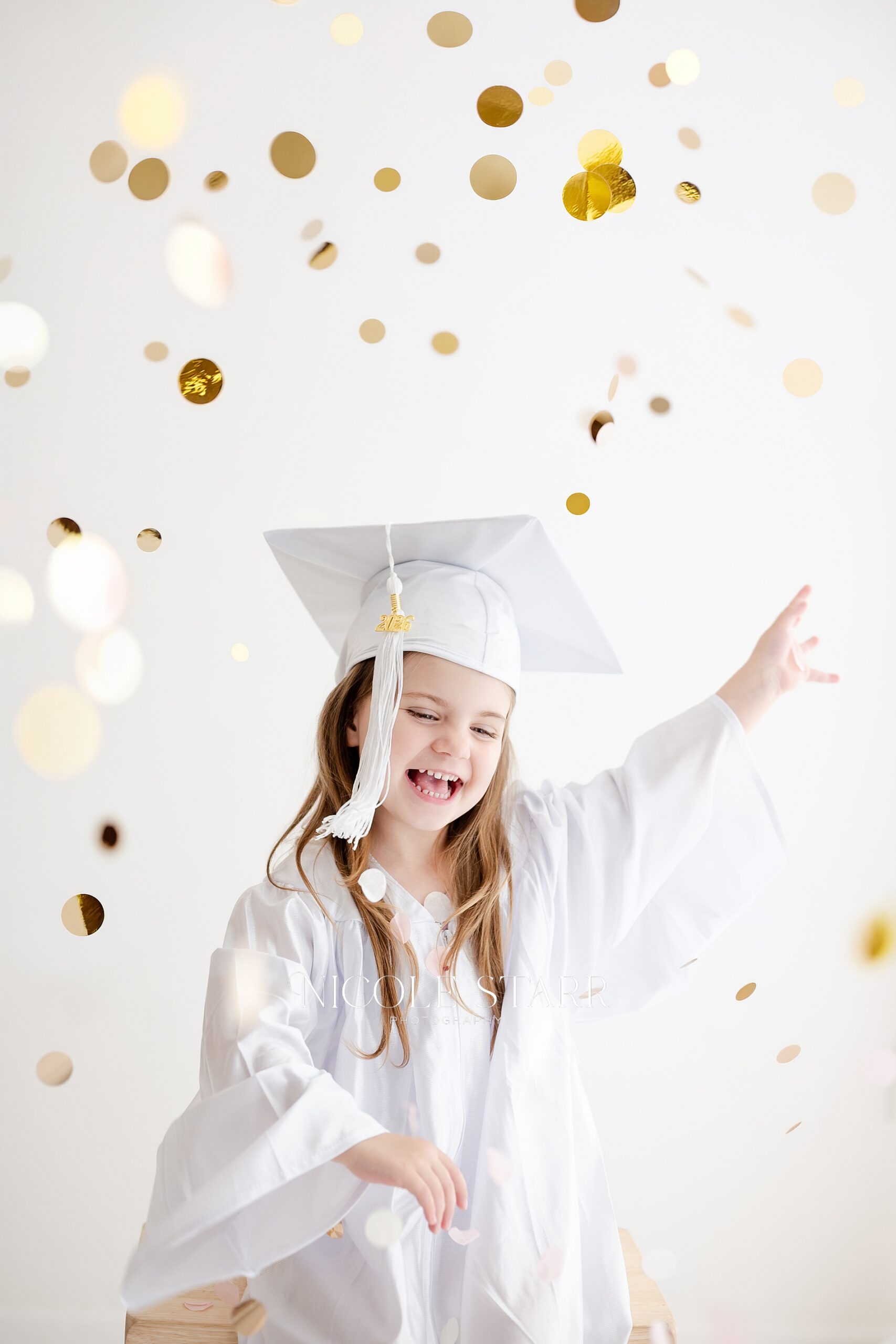 gold confetti in the air around little graduate