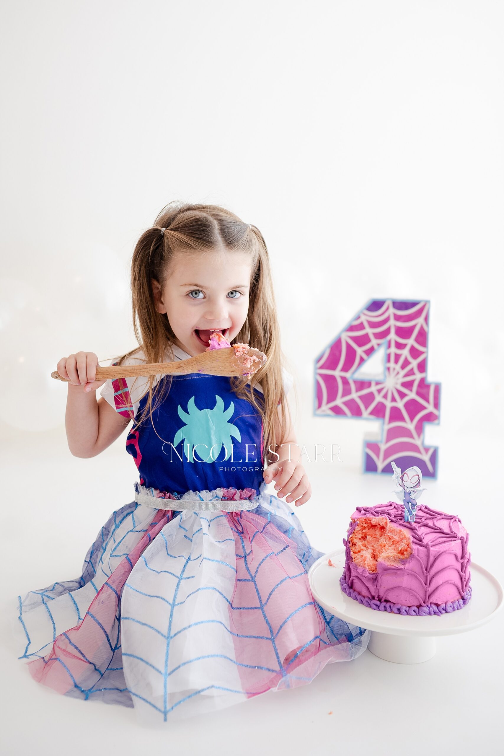 girl eats birthday cake for 4th birthday