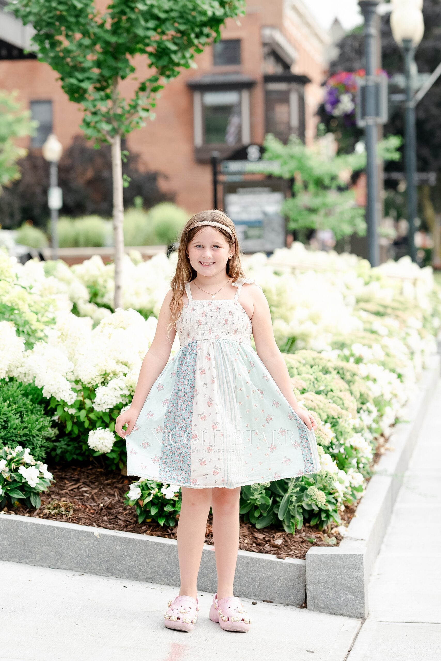 girl in dress by flowers in downtown Saratoga Springs