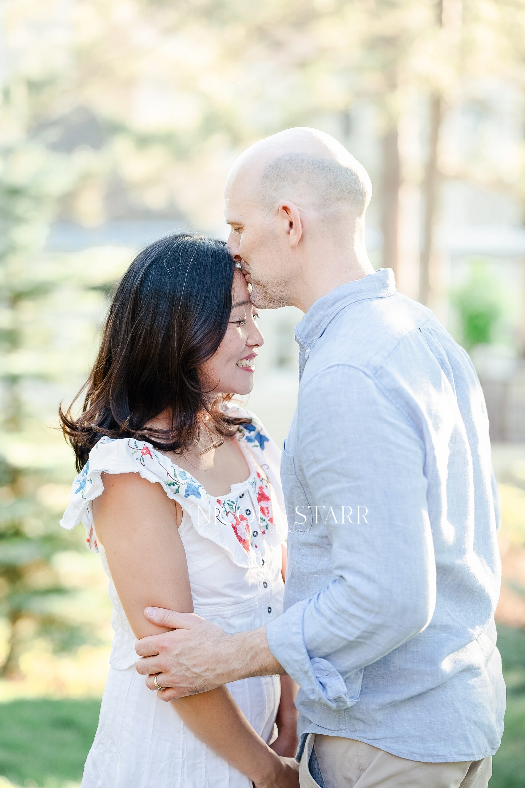 husband kisses wife during family portraits