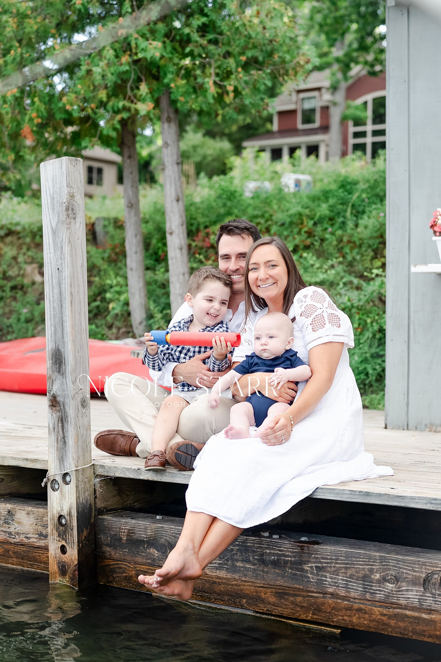 family sits on dock at Lake George
